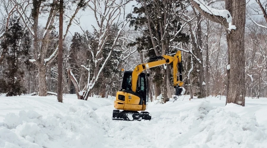 Compact loader removing snow from an outdoor route